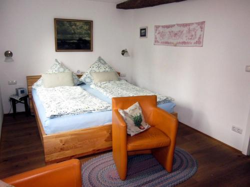 a small bedroom with a bed and a chair at Gästehaus Minkel in Gudensberg