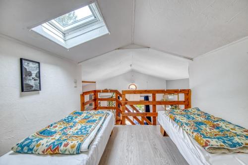 two beds in a room with a skylight at Les chalets de Piqueyrot in Hourtin