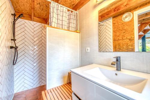 a bathroom with a sink and a shower at Les chalets de Piqueyrot in Hourtin