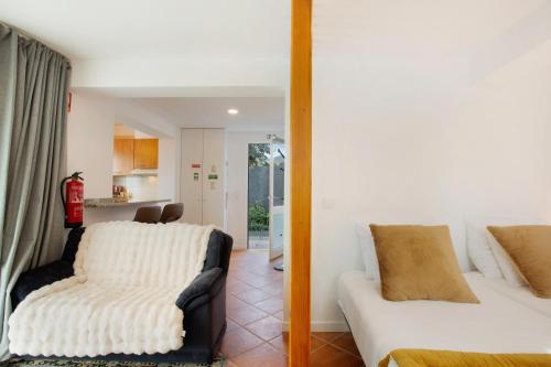 a bedroom with a bed and a couch and a kitchen at Capelos in Funchal