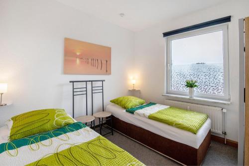 two beds in a room with a window at Ferienwohnung Laage in Laage