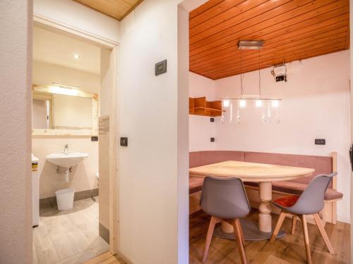 eine Küche und ein Esszimmer mit Tisch und Stühlen in der Unterkunft Chalet Osmar Appartamento 1 in Campitello di Fassa