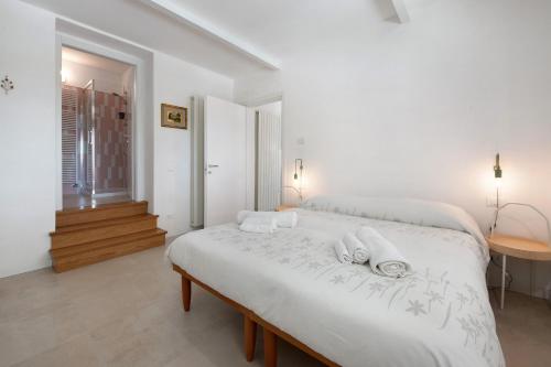 a white bedroom with a large bed with towels on it at Casa Mavi in Corte Franca