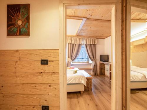 ein Schlafzimmer mit zwei Betten und einem Fenster in der Unterkunft Chalet Osmar Appartamento 1 in Campitello di Fassa