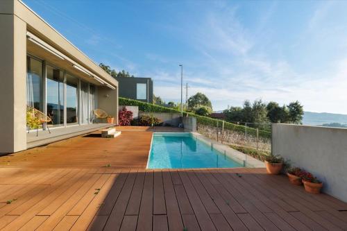 a house with a swimming pool on a wooden deck at Casa da Quinta dos Moinhos in Seixas