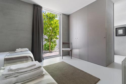 a bedroom with a bed and a large window at Casa da Quinta dos Moinhos in Seixas
