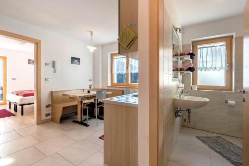 a bathroom with a sink and a toilet and a table at Innerjerberhof Sunnseit in Lauregno