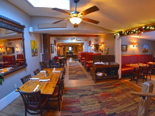 - un restaurant avec des tables et des chaises en bois dans une chambre dans l'établissement Hyde Away Inn, à Waitsfield