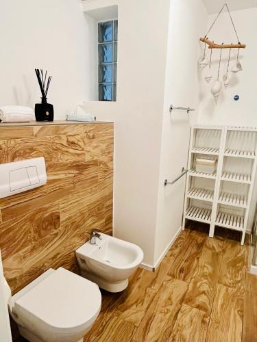 a bathroom with a white toilet and a sink at Residence La Villa Kalliste in Olzano