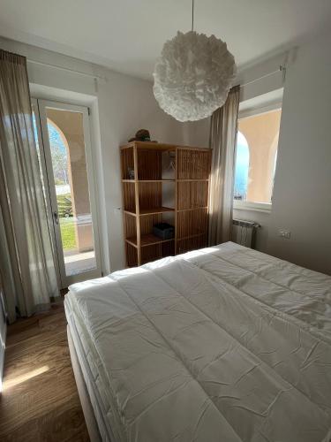 a bedroom with a large bed and a chandelier at Residence La Villa Kalliste in Olzano