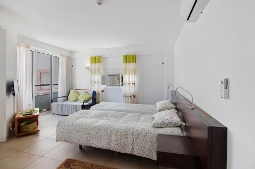 a white bedroom with a bed and a couch at Casa Diouma in Cabanas de Tavira