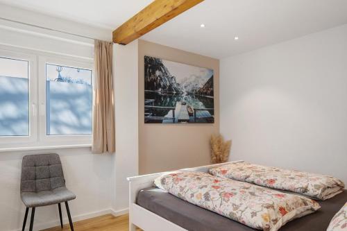 a bedroom with two beds and a chair in it at Kaiserstuhlnest am Rhein in Breisach am Rhein
