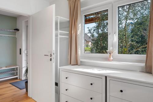 a kitchen with white cabinets and a window at Kaiserstuhlnest am Rhein in Breisach am Rhein