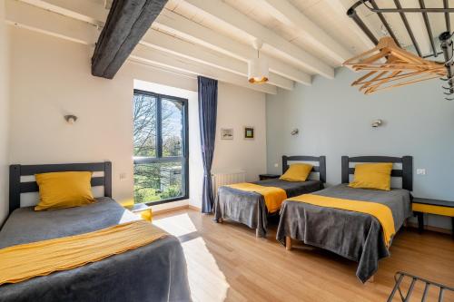 two beds in a room with a window at L'Erdre au moulin in Joué-sur-Erdre