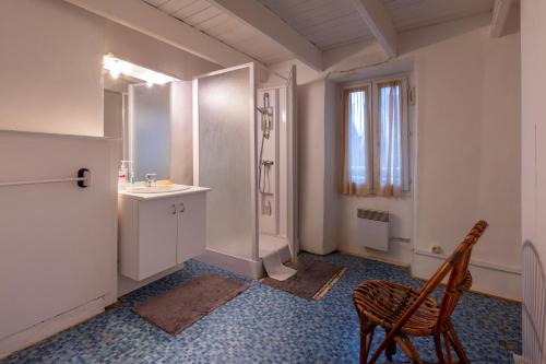 a bathroom with a sink and a mirror and a chair at Maison Sarzeau Centre - La Bernache in Sarzeau