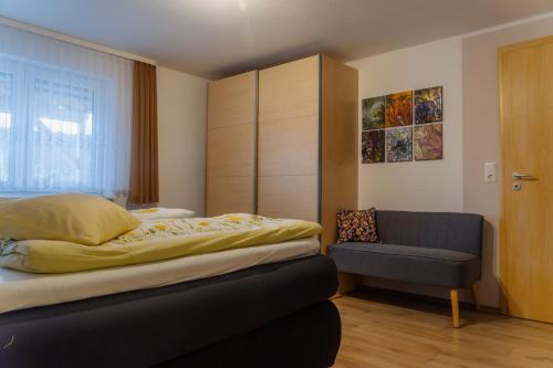 a bedroom with a bed and a chair at Collenberger Ferienwohnung Schäfer in Collenberg