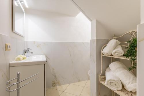 a bathroom with a sink and towels on a shelf at Appartamento Achates in Acate