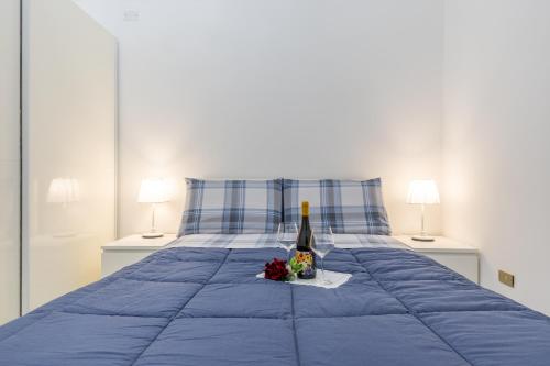 a blue bed with a bottle of wine and flowers on it at Appartamento Achates in Acate