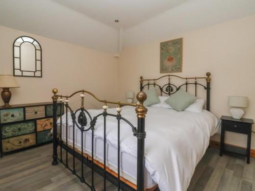 a bedroom with a large bed with white sheets at Meadow View in Hull