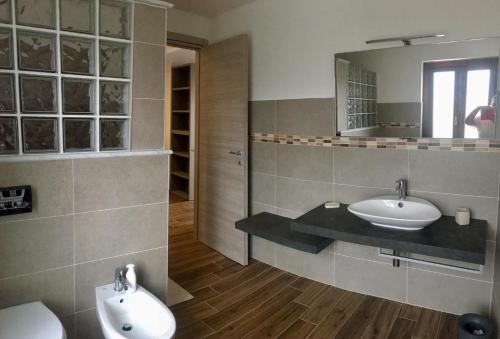 a bathroom with two sinks and a mirror at Agriotto Agriturismo in Savona