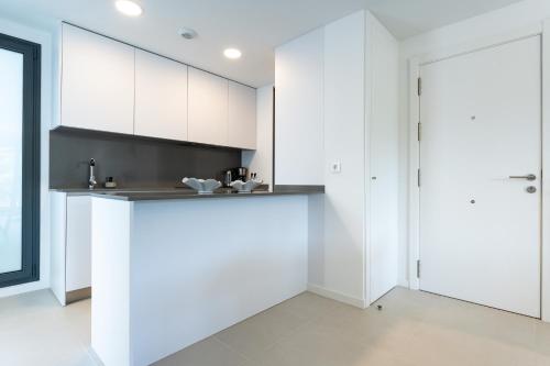 a kitchen with white cabinets and a counter top at Middle Views West in Fuengirola