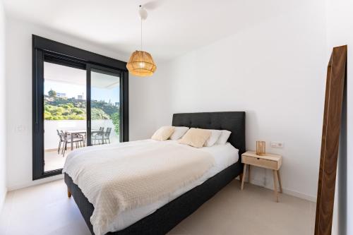 a bedroom with a bed and a large window at Middle Views West in Fuengirola