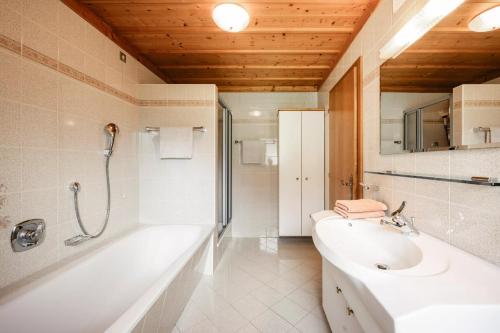 a bathroom with a tub and a sink and a toilet at Rieplechn App in Sand in Taufers