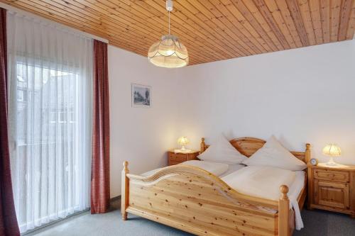 a bedroom with a wooden bed and a window at Ferienhaus im Grund in Hinterzarten