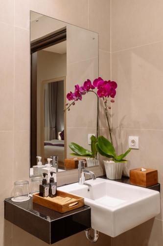 a bathroom with a sink and a mirror at The Evitel Resort Ubud in Ubud