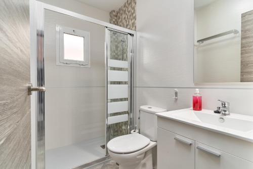 a white bathroom with a toilet and a sink at Nerja Boutique 101 Deluxe in Nerja