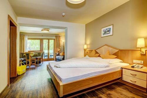 a bedroom with a large bed and a living room at Alpenhof Lodge Alpin Superior in Saltusio