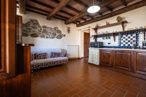 ein Wohnzimmer mit Sofa und eine Küche in der Unterkunft Edera in Arcidosso