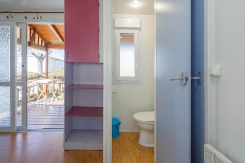 a bathroom with a toilet and a sliding door at Bungalow E in Pontevedra