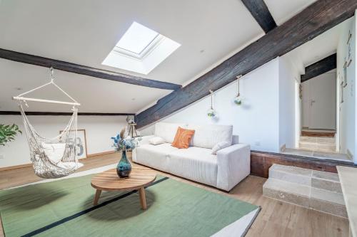 a living room with a couch and a swing at Le Somail - Louis 14 in Ginestas