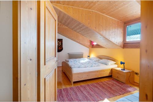 a small bedroom with a bed and a staircase at Regalterhof Eppan in San Paolo