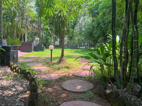 a path in a park with trees and plants at Mint Inside Garden in Varkala