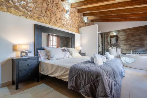 a bedroom with a large bed and a bath tub at Cas Mercader in Algaida