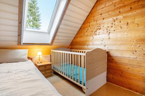 a small bedroom with a crib and a window at Feriendomizil Fliedereck in Malchin