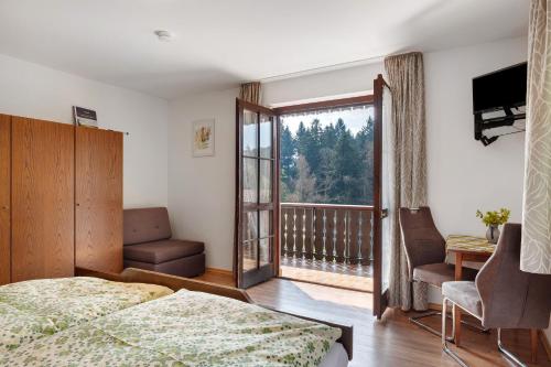 a bedroom with a bed and a window with a balcony at Bergbauernhof 1910 in Oberharmersbach