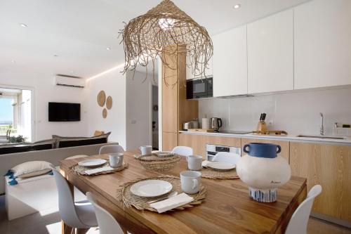 a kitchen and dining room with a wooden table and chairs at Luxury Boho Style Apartment Nazaré in Nazaré