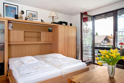 a bedroom with a bed and a vase of flowers at Ferienwohnung Bergrose in Obermaiselstein