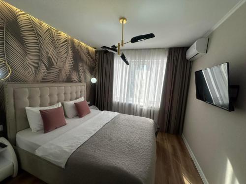a bedroom with a large bed with pink pillows at Sweethome Riscani in Chişinău