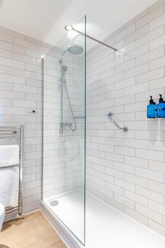 a shower with a glass door in a bathroom at The Swan Inn by Innkeeper's Collection in Horning