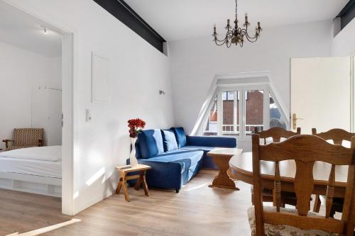 a living room with a blue couch and a table at Die Alter Schwede Wohnung 2 in Vechta