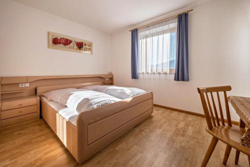 a bed in a room with a table and a window at Apartment Dolomitenblick in Mühlbach