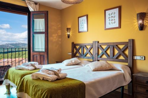 a bedroom with two beds with towels on them at Las Puentes 2 in Candelario