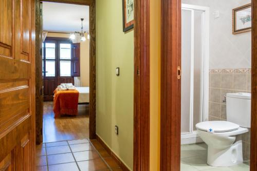 a bathroom with a toilet and a tub in a room at Las Puentes 2 in Candelario