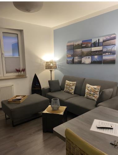 a living room with a couch and a table at Ferienwohnungen Felix und Jan in Horumersiel