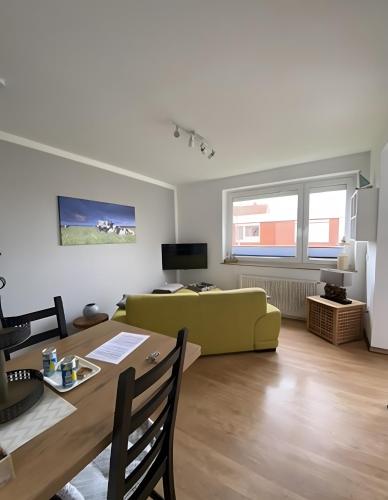 a living room with a green couch and a table at Ferienwohnungen Felix und Jan in Horumersiel