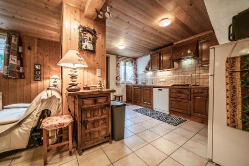 サン・ジャン・ドルプにあるChalet Ermenaの木製のキャビネットとランプ付きのテーブルを備えたキッチン